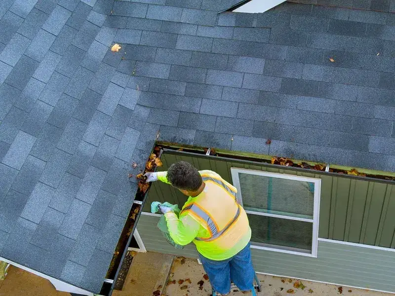 From a ladder at the eave, working along the edge of an asphalt shingle roof